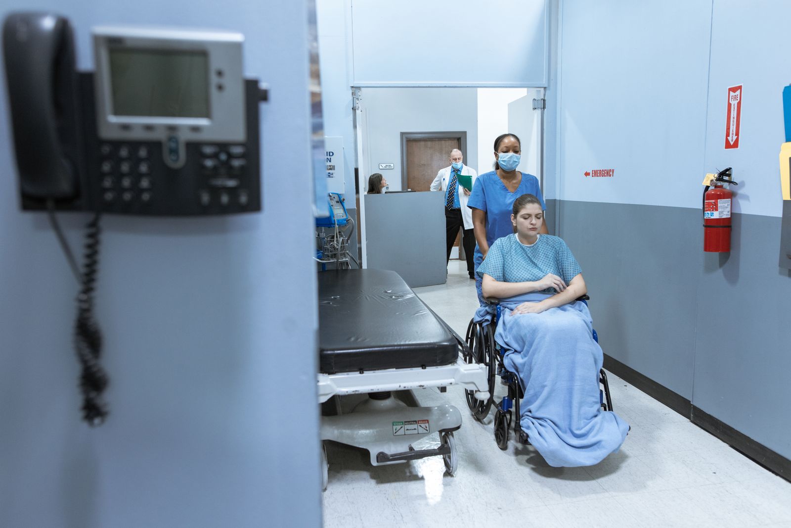 Healthcare professionals assisting a patient in a modern hospital corridor